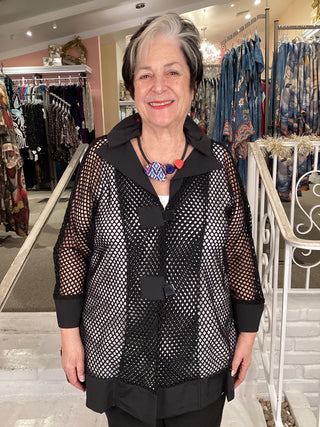 Woman wearing a black fishnet top in a store setting